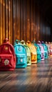 Colorful childrens schoolbags on a wooden floor, blue room