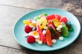 Colorful childs sweets and treats in plate on wooden table