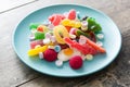 Colorful childs sweets and treats in plate on wood