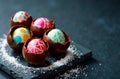 Colorful chocolate eggs filled with candy sit on a dark slate board, making a festive display Royalty Free Stock Photo