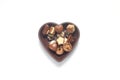 Colorful Chocolates in a heart-shaped bowl. On a white background.