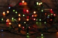 Colorful christmas garland lights on brown wooden background. Christmas Light with Copyspace for New Year Frame or Christmas Layou