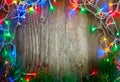 Colorful Christmas garland lights on wooden rustic background. Christmas decorations.