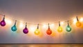 Colorful Christmas light bulbs garland on a white wall background Royalty Free Stock Photo