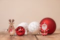 Colorful Christmas ornament balls with small wooden deer and Santa Claus figurines on the table Royalty Free Stock Photo