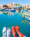 colorful Christmas socks and Maltese fishing boats at the harbor of the village Marsaxlokk Malta Royalty Free Stock Photo