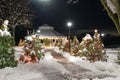 colorful Christmas trees in park in snowy night with decorations and Christmas lights. Holy night concept