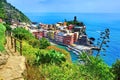 Above view of the colorful Cinque Terre village of Vernazza with hiking trail and blue sea