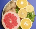 Colorful cirtus slices over blue background. Cut lemons and grapefruit with ginger on a plate Royalty Free Stock Photo