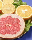 Colorful cirtus slices over blue background. Cut lemons and grapefruit with ginger on a plate Royalty Free Stock Photo