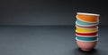 Colorful clean ceramic bowls stacked on black color background, copy space Royalty Free Stock Photo