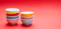Colorful clean ceramic bowls stacked on red color background, copy space Royalty Free Stock Photo
