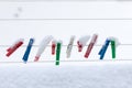 Colorful clips washing laundry covered snow strip rope outdoor. Winter.