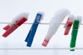 Colorful clips washing laundry covered snow strip rope outdoor. Winter.