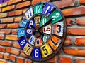 A colorful clock made from license plates on a brick wall Royalty Free Stock Photo