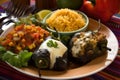 Colorful close-up of Chiles Rellenos stuffed with a mix of sauteed vegetables and cheese, served with a side of corn