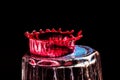 Colorful close-up a red drop is split on the glass in the form of a crown Royalty Free Stock Photo