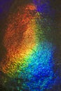 Colorful close-up of a textured holographic sheet with vibrant rainbow light Royalty Free Stock Photo