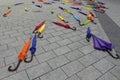 Colorful closed umbrellas scattered on the sidewalk