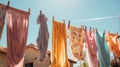 Colorful clothes hanging to dry on a laundry line and sun shining in the blue sky. Generative AI Royalty Free Stock Photo