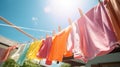 Colorful clothes hanging to dry on a laundry line and sun shining in the blue sky. Generative AI Royalty Free Stock Photo