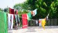 Colorful clothes hanging to dry on a laundry line and sun shining in the blue sky Royalty Free Stock Photo