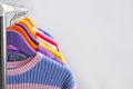 Colorful clothes hanging on wardrobe rack against light background, closeup. Royalty Free Stock Photo