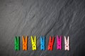 Colorful clothes pegs on black board