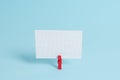 Colorful clothespin and rectangle square shaped colored paper in a blue background. Red clip hanging a note reminder in Royalty Free Stock Photo