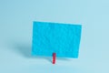 Colorful clothespin and rectangle square shaped colored paper in a blue background. Red clip hanging a note reminder in Royalty Free Stock Photo