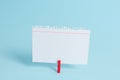 Colorful clothespin and rectangle square shaped colored paper in a blue background. Red clip hanging a note reminder in Royalty Free Stock Photo