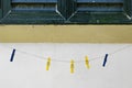 Colorful clothespins clipped to a string against a white wall Royalty Free Stock Photo