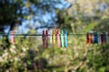 Colorful clothespins hanging in a row on clothesline in summer