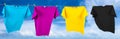 Colorful CMYK colored t-shirts on clothes line in front blue sky summer background. Cyan magenta yellow key symbol and printing Royalty Free Stock Photo