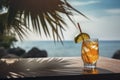 Colorful cocktail or juice in a glass decorated on a wooden table on blurred seascape background