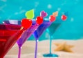 Colorful cocktail in a row with cherry on tropical sand beach