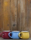 Colorful coffee cups on wooden table over grunge background Royalty Free Stock Photo