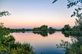 Colorful cold sunset on the lake, among the green plants. Salamanca, Spain