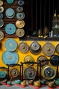 A colorful collection of ornamental gongs, sound bowls and buddha statues hanging on a yellow wall in a shop front in Hoi An, Royalty Free Stock Photo