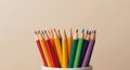 A Colorful Collection. Sharpened Color Pencils in a White Holder on Beige Background Royalty Free Stock Photo
