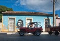Colorful Colonial aged town with classic car, building, revolution wall, modern street in Trinidad, Cuba, America.