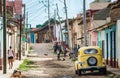 Colorful Caribbean aged village with cobblestone street, classic yellow car and Colonial house, Trinidad, Cuba, America. Royalty Free Stock Photo