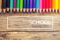 Colorful color pencils on old wooden background table with text back to school in white border frame Royalty Free Stock Photo