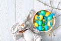 Colorful colored Easter chicken eggs in a wicker basket with feathers, rabbit bunny toy, willow branches, spring, Easter concept Royalty Free Stock Photo