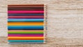 Colorful colored pencils arranged on a wooden table Royalty Free Stock Photo