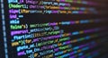 Colorful computer code glowing on screen software development programming technology abstract background Royalty Free Stock Photo