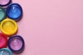 Colorful condoms on pink background, flat lay. Space for text Royalty Free Stock Photo