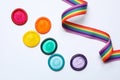 Colorful condoms and rainbow ribbon on background, top view. LGBT concept Royalty Free Stock Photo