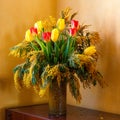 Colorful congratulatory spring bouquet of tulips and Mimosa in a clay vase. Small focus selected. Royalty Free Stock Photo