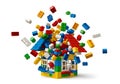 Colorful construction toy bricks exploding from a house structure on white. Royalty Free Stock Photo